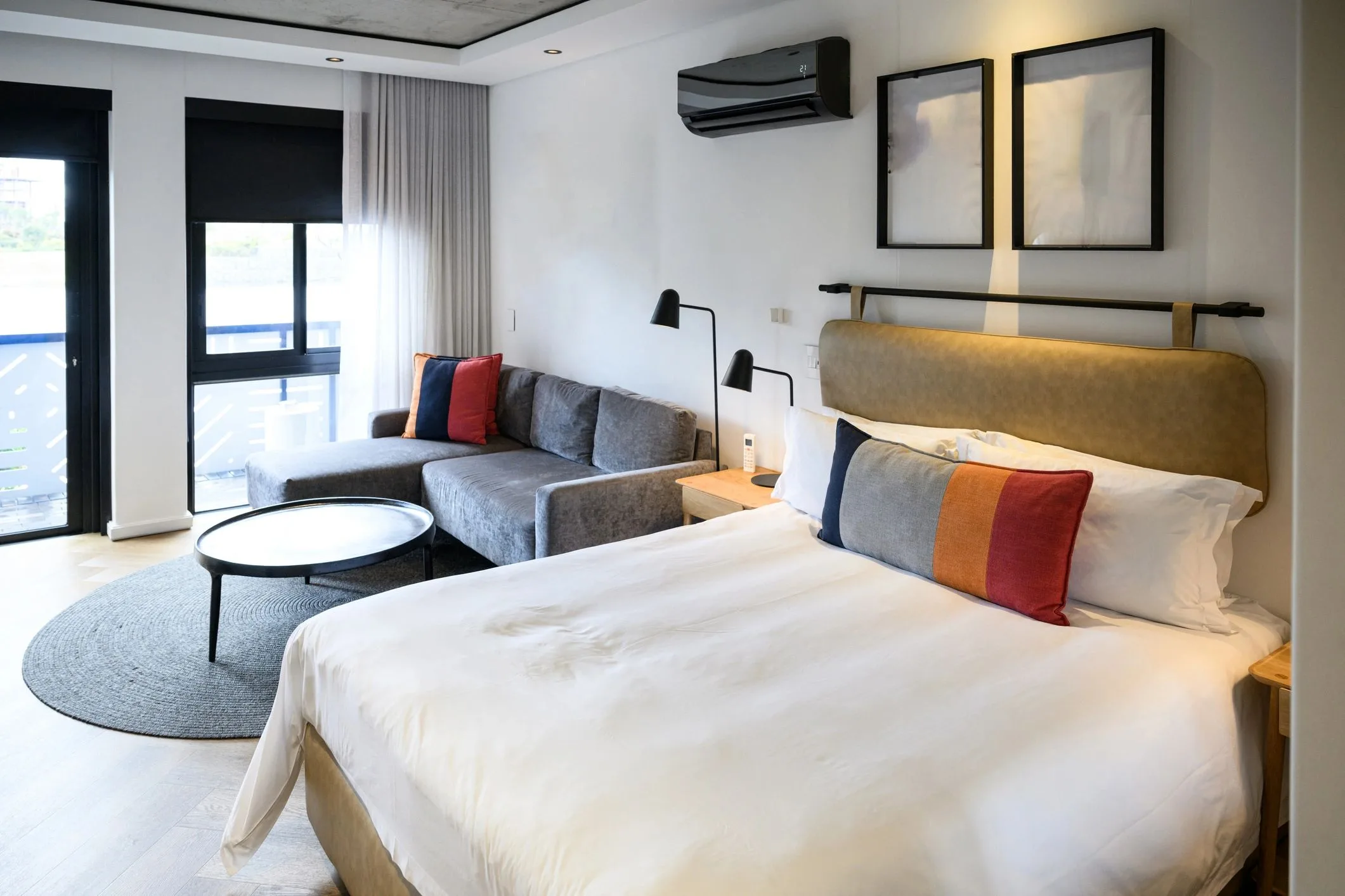 Contemporary hotel room interior with a king bed and a clean minimalist layout